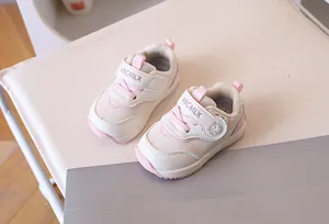 Dettaglio delle scarpe da passeggio per neonati rosa e bianche con velcro e rete