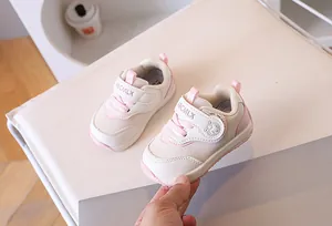 Dettaglio di scarpe da camminata rosa e beige con cinturino regolabile in velcro e rete