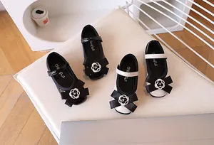 Detail of girl's Mary Jane shoes featuring large bows and silver camellia metal accents