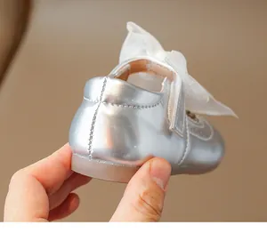 Detailed view of silver metallic princess shoe with large organza bow and stitching