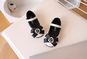Detail of girls Mary Jane shoes with patent leather finish and floral bow embellishment