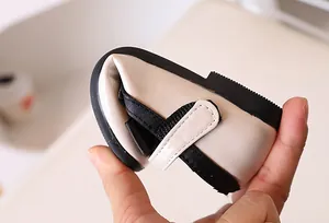 Macro shot showing the ultra-flexible black sole of the beige girl's patent leather shoe