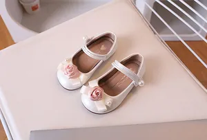 Detalle de zapato Mary Jane crema con rosa de satén, perla y adorno de lazo