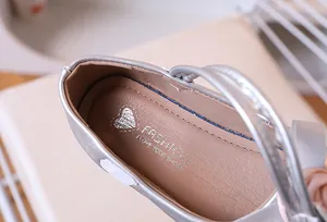 Vista macro detallada del interior de la zapatilla Mary Jane plateada con diseño de corazón