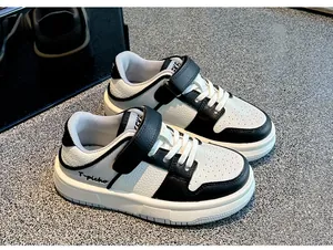 Vista detallada de zapatillas para niños en cuero blanco y negro con cierre de velcro