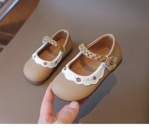 Detail mit Blumenstickerei und geflochtenem Riemen an Khaki Mädchen Mary Janes