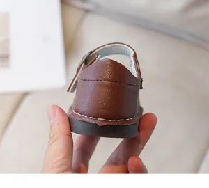 Gros plan de chaussures en cuir marron pour enfants avec coutures et boucle métallique