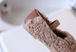 Nahaufnahme der Kinder-Slipper mit braunem Teddyfell und Fersenverstärkung aus Leder
