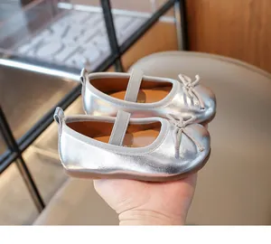 Detail of silver metallic girl's Mary Jane flat shoe with bow and elastic strap