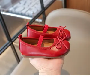 Close-up of red leather Mary Jane shoes featuring a stylish bow and durable rubber sole