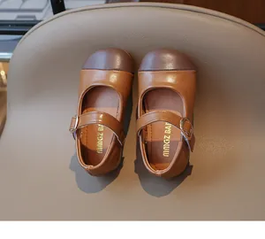 Top view of two-tone Mary Jane shoes with brown leather and metallic buckle detail