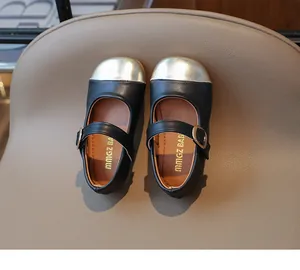 Top view of girls' black Mary Janes with gold metallic toe caps and buckle straps