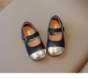 Detail of girls Mary Jane shoes with black matte leather and metallic gold toe cap buckle