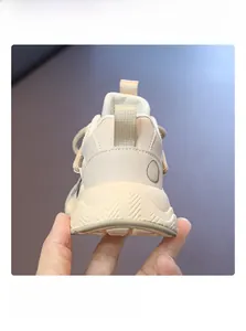 Detail shot of the heel tab and GAHO leather logo on beige kids' sneakers