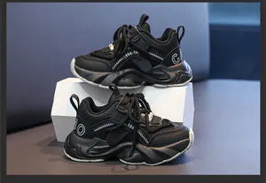 Detailed macro view of black children's chunky sneakers with white stitching and velcro