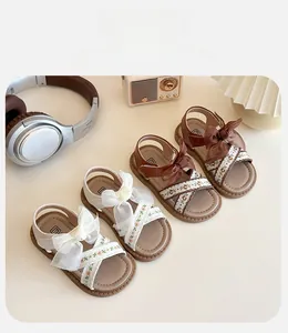 Gros plan de sandales de princesse pour filles avec broderies et grands nœuds en tulle