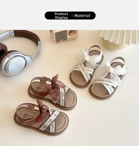 Détail de sandales enfant avec nœud en tulle, broderie florale et fermeture velcro