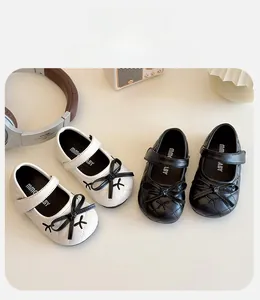 Detail of quilted Mary Jane shoes with black bows and velcro straps for toddlers