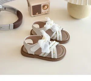 Détail de sandales princesse pour filles avec broderie florale et nœud en résille