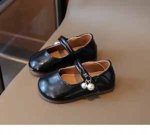 Detailed side view of black Mary Jane leather shoes with elegant pearl charms for girls
