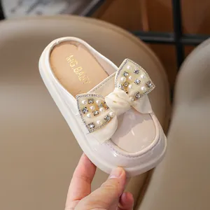 Beige faux leather girls' closed-toe slippers with elegant lace bow and pearl details