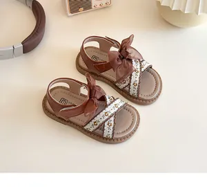 Détail de sandales fille avec broderie florale, nœud élégant et semelle en caoutchouc souple