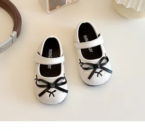 Top view of white quilted Mary Jane shoes for girls featuring a black bow and velcro strap