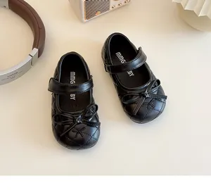 Detailed top view of black quilted girls' Mary Jane shoes with classic bow accents
