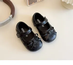 Detailed top view of black quilted leather baby Mary Jane shoes with bow and velcro strap