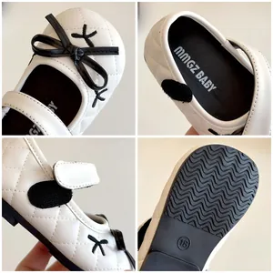 Quilted white Mary Jane baby shoes with black bow and non-slip rubber sole detail