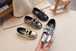Dettaglio di scarpe Mary Jane da bambina con doppi fiocchi lucidi in quattro colori metallici