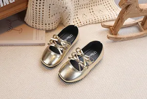 Dettaglio scarpe Mary Jane dorate da bambina con triplo fiocco e finitura lucida