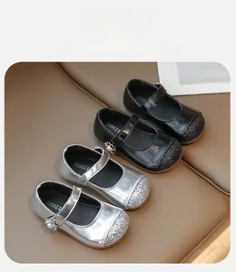 Detail of girls' Mary Jane shoes featuring sparkly glitter toes and elegant pearl buckles