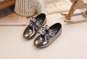 Dettaglio di scarpe Mary Jane bronzo metallizzato per bambine con doppi fiocchi e finitura lucida