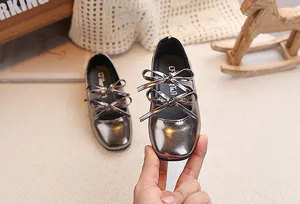 Dettaglio scarpe Mary Jane da bambina in pelle verniciata con doppio fiocco elegante