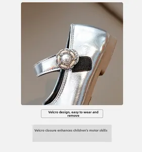 Close-up of silver Mary Jane shoes featuring easy Velcro strap and pearl flower detail