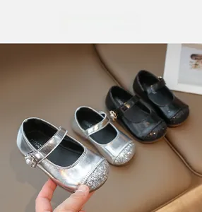 Detail of girls Mary Jane shoes featuring sequin toe caps and pearl flower accents