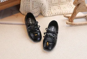 Dettaglio di scarpe Mary Jane nere in vernice per bambine con doppio fiocco lucido