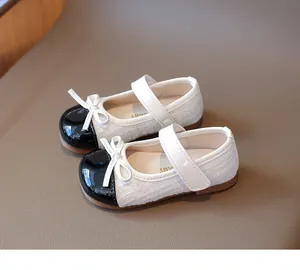 Detail of girls Mary Jane shoes featuring tweed texture and glossy black patent leather toe