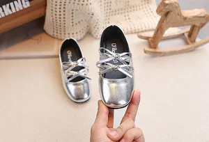 Dettaglio delle scarpe da principessa argento lucido con elegante fiocco doppio