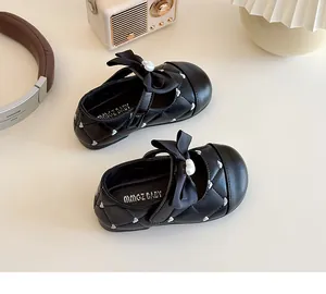 Detail van zwarte gewatteerde Mary Jane schoenen voor meisjes met hartborduursel en parel