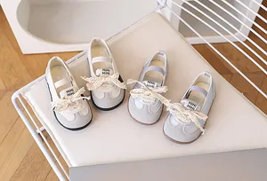 Dettaglio di scarpe Mary Jane per bambini con fiocchi in pizzo e suole in gomma