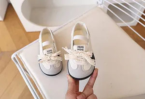 Dettaglio scarpe casual per bambini con fiocco in pizzo e pelle sintetica morbida