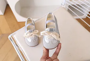 Dettaglio di scarpa argento per bambina con fiocco in pizzo ed elastico flessibile