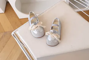 Dettaglio di sneakers per bambine con fiocco in pizzo e logo HiHi su pelle argento