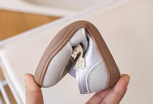 Suola in gomma flessibile su scarpe argento da bambina che mostra flessibilità e comfort