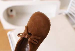 Détail macro de chaussure marron en daim pour fille avec nœud et bout rond élégant