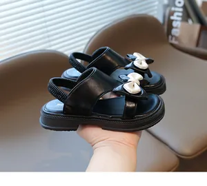 Detailansicht der Kindersandalen mit Schleife, dicker rutschfester Sohle und schwarzem Leder