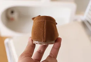 Vue détaillée de la couture artisanale au talon des mocassins pour enfants en daim