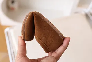 Détail de chaussures en daim marron pour enfants montrant une grande souplesse et semelle